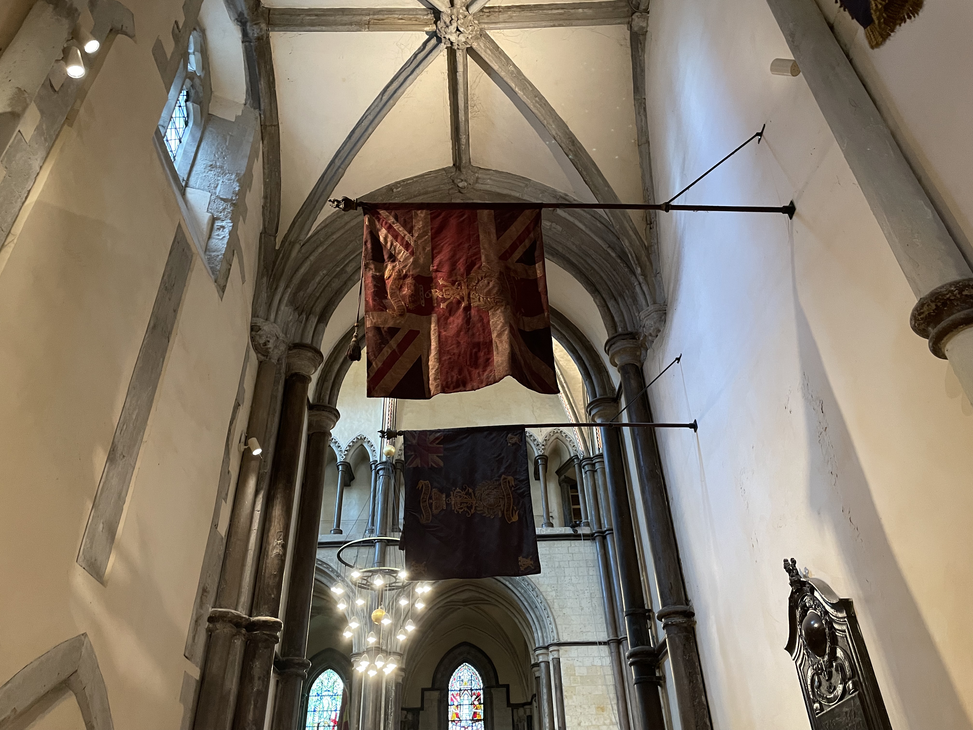 Photograph of the military colours and standards hanging in the north quire aisle.