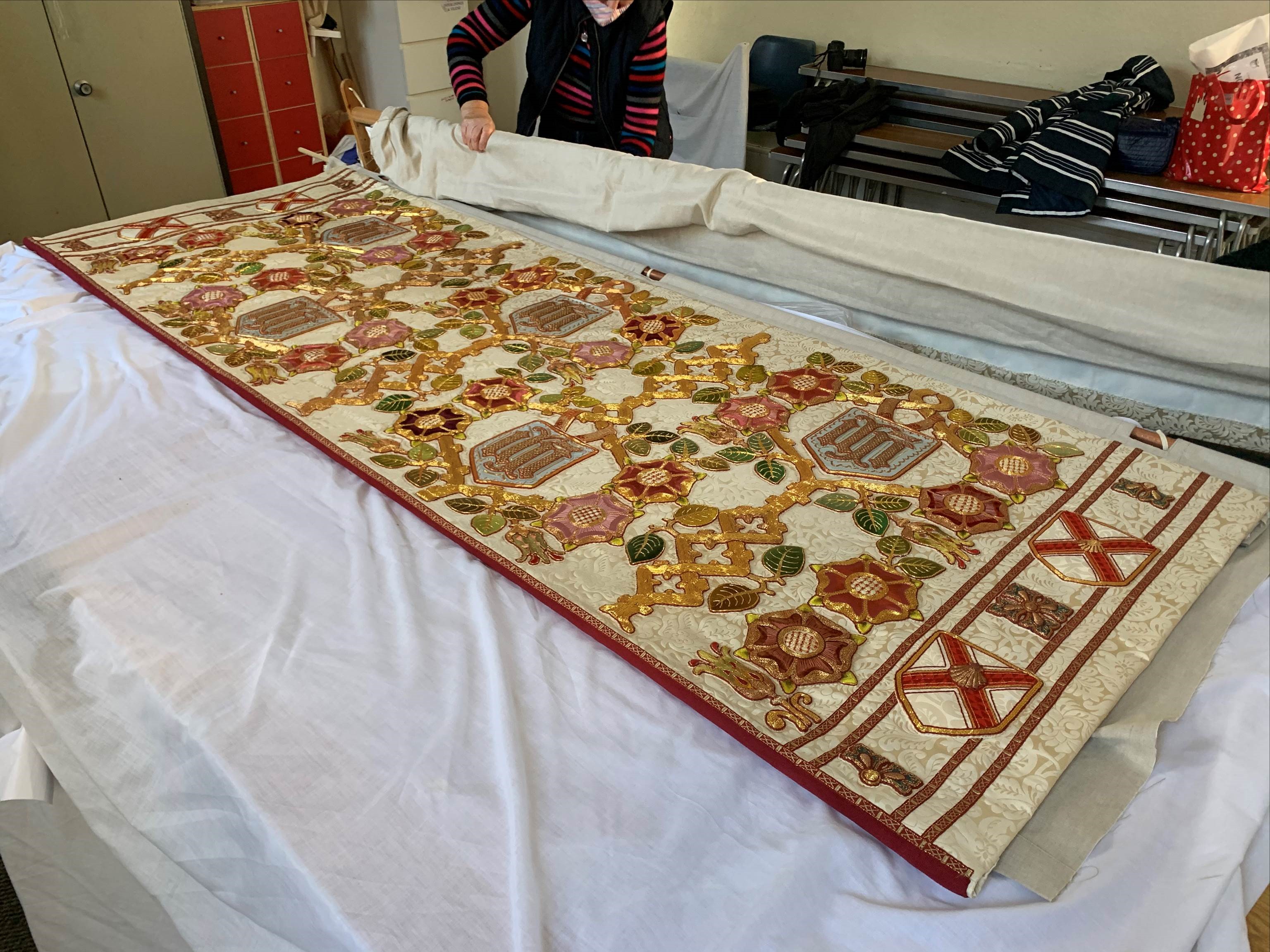 Photograph of the festal frontal undergoing repairs by the Guild of Embroiderers.
